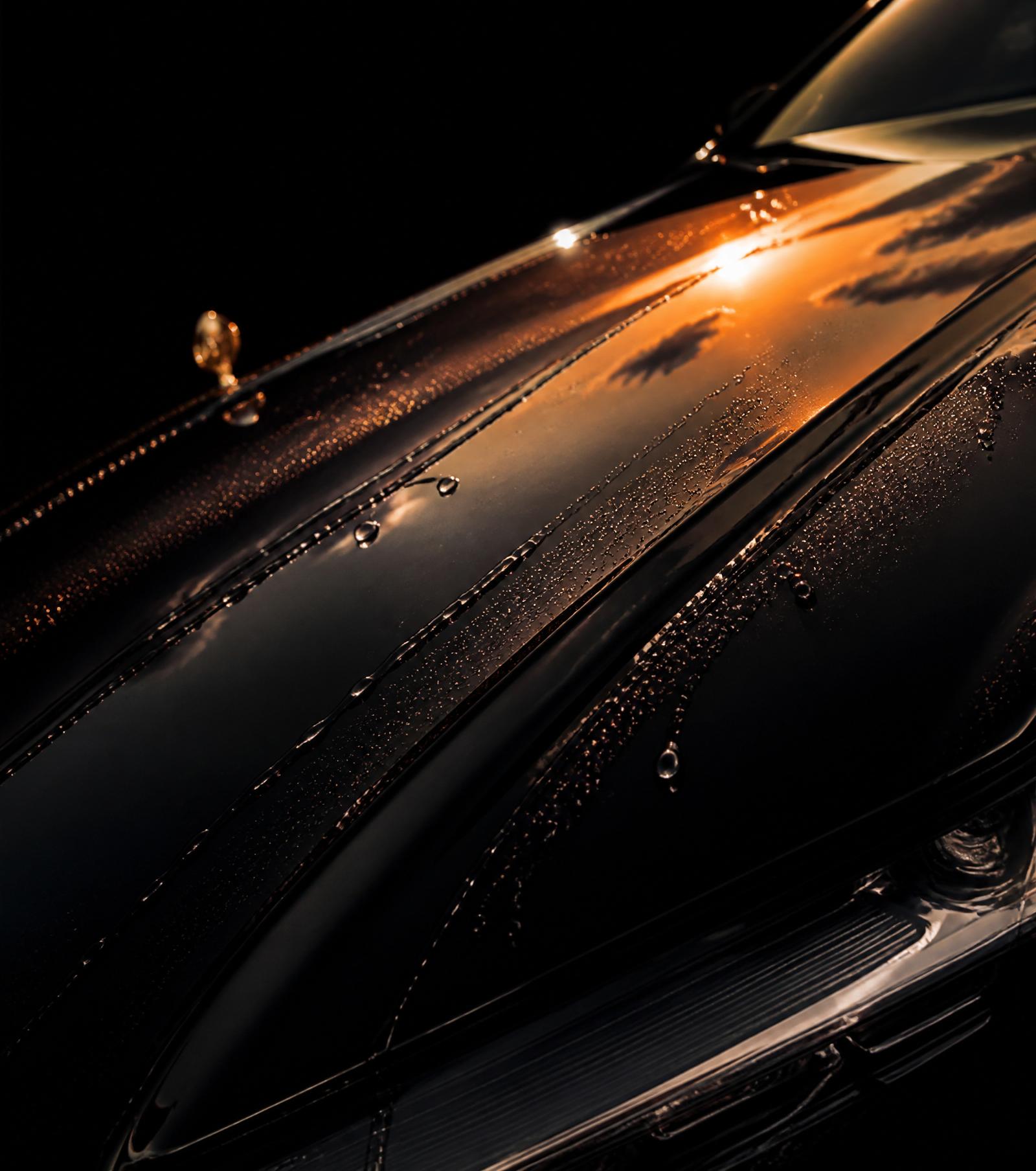 Sunset reflection dripping across a hand-detailed black hood